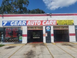 Exterior of 7th Gear Auto Care showing bays and sign that reads oil changes, ac repair, tire repair, and other car services